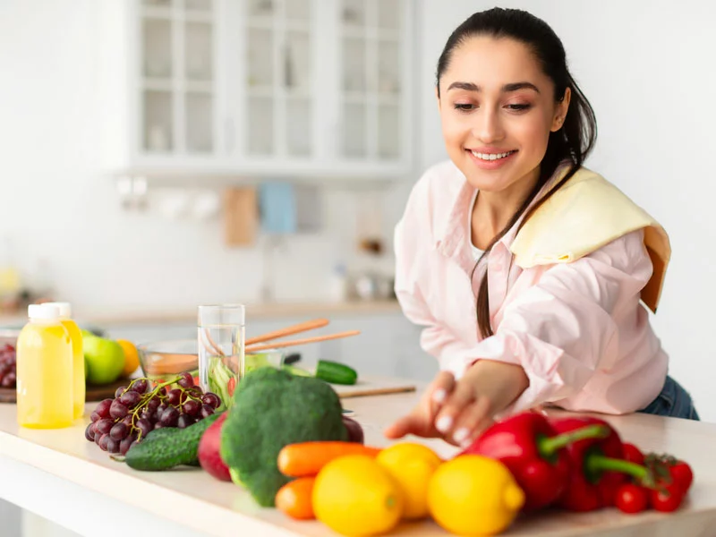 woman reaching for vegetables on counter